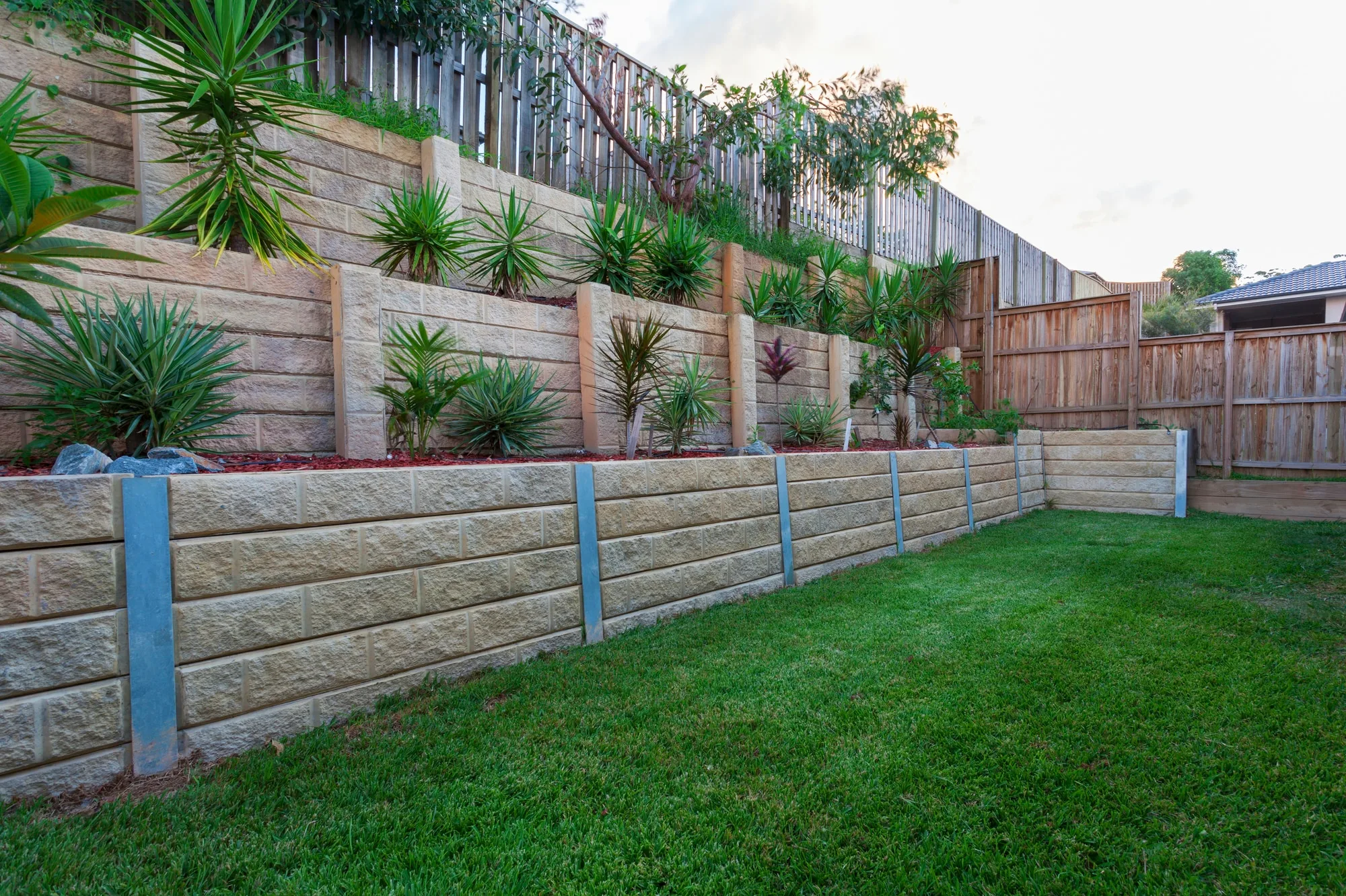 Concrete sleeper retaining wall installed on a sloping residential property in Moreton Bay